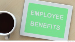 Employee benefits written on tablet next to coffee