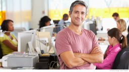 Businessman in office with employees at computers