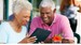 senior-couple-using-table-computer-at-outdoor-cafe